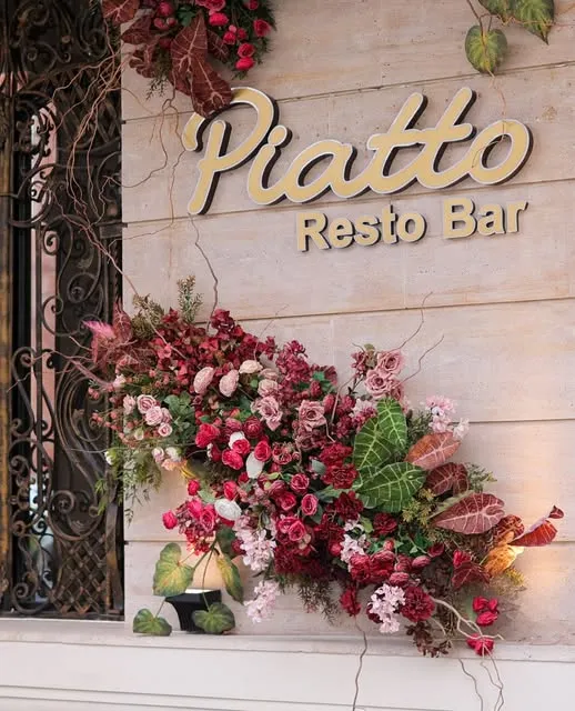 Piatto Resto Bar sign with flowers
